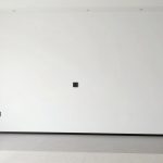 czarne gniazdka na białej ścianie w nowoczesnym salonie z minimalistycznym wystrojem