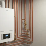 Nowoczesny kocioł gazowy kondensacyjny zainstalowany w kotłowni domowej z rurociągami i systemem automatyki